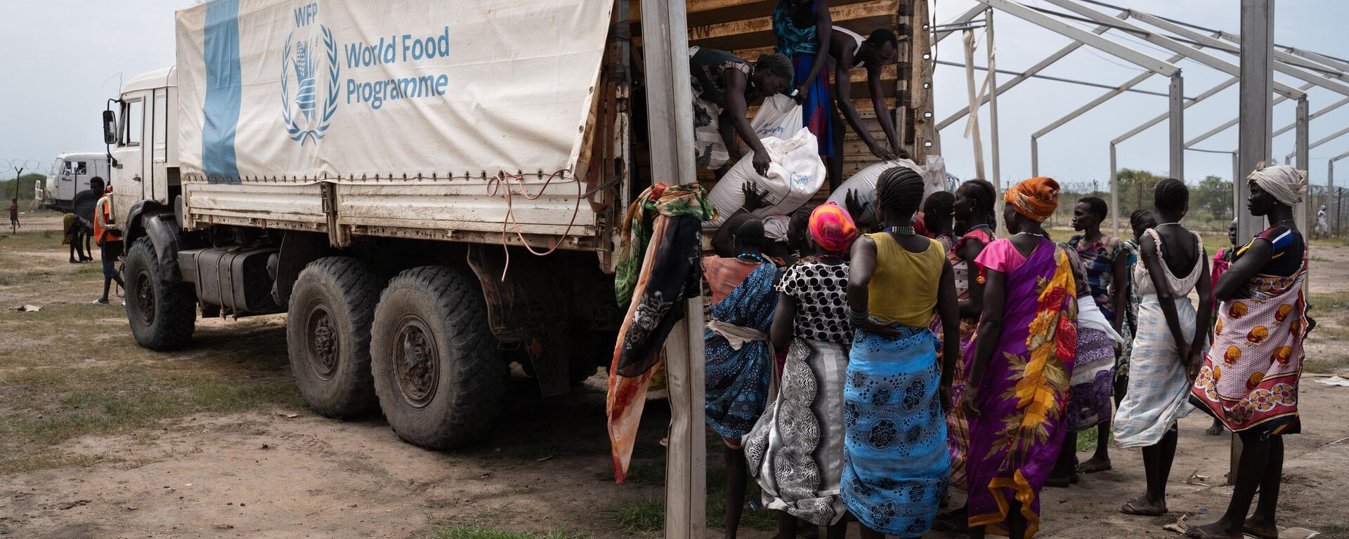 Women from Murle ethnic group unload bags of sorghum from a truck during a food distribution by United Nations World Food Programme (WFP) in Gumuruk, South Sudan, on June 10, 2021, as their village where recently attacked by armed youth group.  - Sputnik International, 1920, 16.04.2023