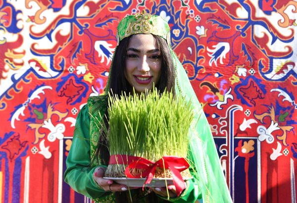 A girl holds in her hands semeni - wheat sprouted in a plate at the celebration of Nowruz in Kazan. - Sputnik International