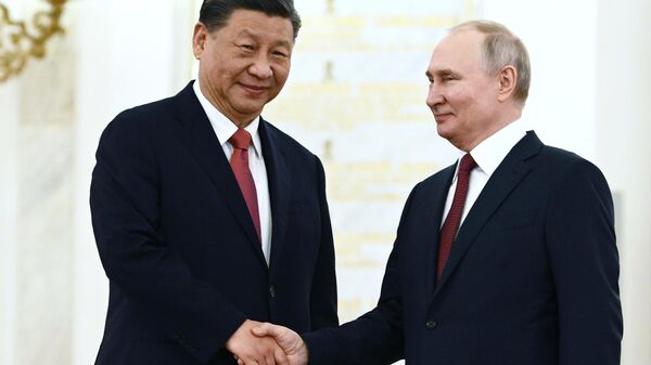 Chinese President Xi Jinping and Russian President Vladimir Putin shake hands - Sputnik International
