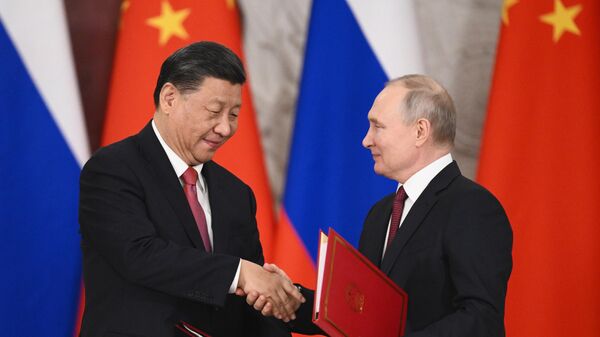 Chinese Leader Xi Jinping and Russian President Vladimir Putin shake hands after signing a joint statement on deepening comprehensive partnership and strategic cooperation and on the plan for development of key areas of the economic cooperation until 2030 at the Kremlin, in Moscow, Russia. - Sputnik International