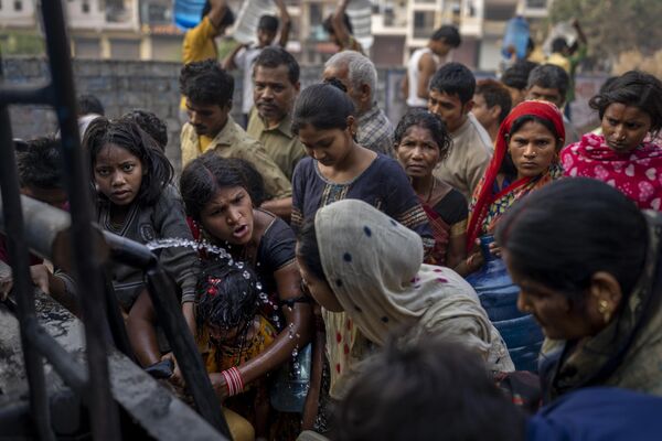 Women argue as they collect drinking water from a mobile water tanker on World Water Day in a residential area in New Delhi, India, Wednesday, March 22, 2023. (AP Photo/Altaf Qadri) - Sputnik International