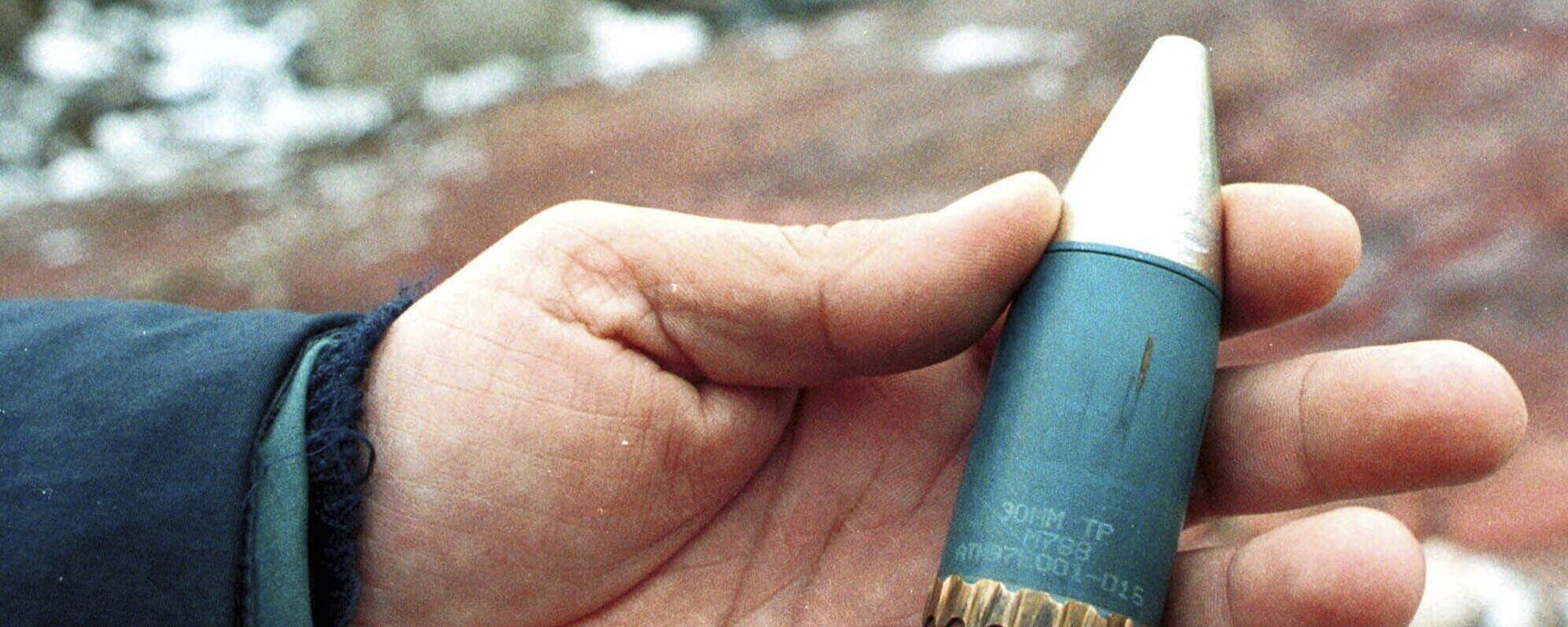 A member of a radiation team holds a 30mm armor-piercing shell containing depleted uranium, used by NATO during air strikes on Bosnia in 1995, which was found in a former military factory in the suburb of Vogosca, near Sarajevo, Jan. 15, 2001. - Sputnik International, 1920, 04.09.2023