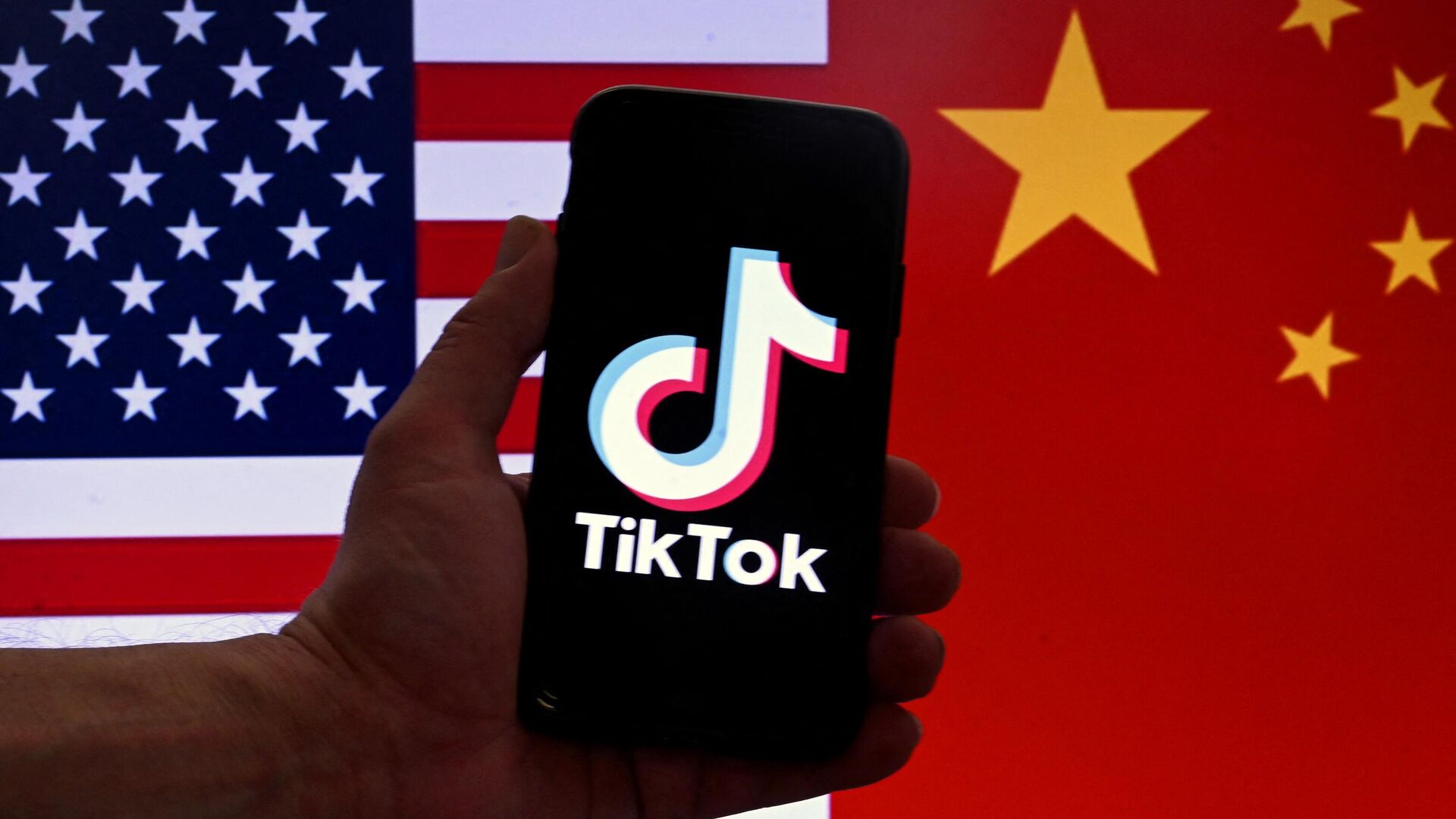 In this photo illustration the social media application logo for TikTok is displayed on the screen of an iPhone in front of a US flag and Chinese flag background in Washington, DC, on March 16, 2023 - Sputnik International, 1920, 27.03.2023
