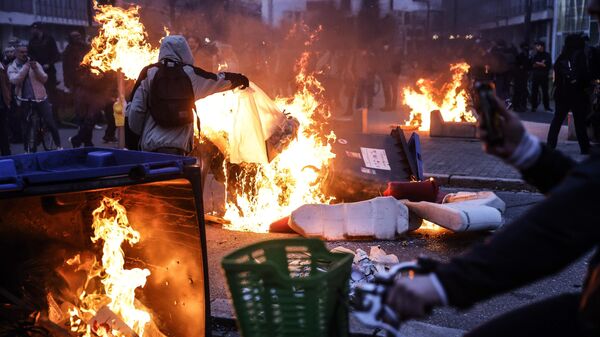 Protesters burn dustbins at the end of a demonstration in Strasbourg, France, Thursday, March 23, 2023. French unions are holding their first mass demonstrations Thursday since President Emmanuel Macron enflamed public anger by forcing a higher retirement age through parliament without a vote. - Sputnik International