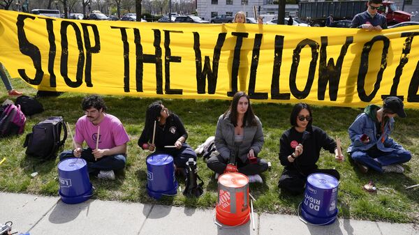 Demonstrators protest against the Biden administration's approval of the Willow oil-drilling project before a scheduled speech by Biden at the Department of the Interior in Washington, Tuesday, March 21, 2023. - Sputnik International