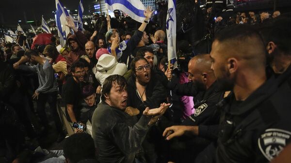 Israeli police scuffle with demonstrators blocking a highway during a protest against plans by Prime Minister Benjamin Netanyahu's government to overhaul the judicial system in Tel Aviv, Israel, Saturday, March 25, 2023.  - Sputnik International