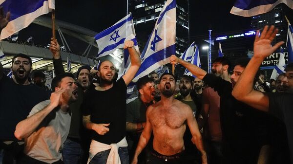 Israelis opposed to Prime Minister Benjamin Netanyahu's judicial overhaul plan block a highway during a protest moments after the Israeli leader fired his defense minister, in Tel Aviv, Israel, Sunday, March 26, 2023.  - Sputnik International