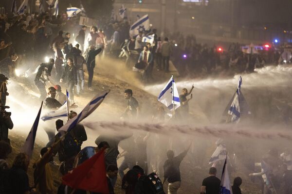 Israeli police use a water cannon to disperse demonstrators blocking a highway during a protest against plans by Prime Minister Benjamin Netanyahu&#x27;s government to overhaul the judicial system in Tel Aviv, Israel. - Sputnik International