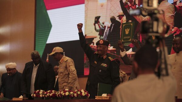 Sudan's Army chief Gen. Abdel-Fattah Burhan, center, holds up his fist as others hold a document following the signature of an initial deal aimed at ending a deep crisis caused by last year's military coup, in Khartoum, Sudan, Monday, Dec. 5, 2022.  - Sputnik International
