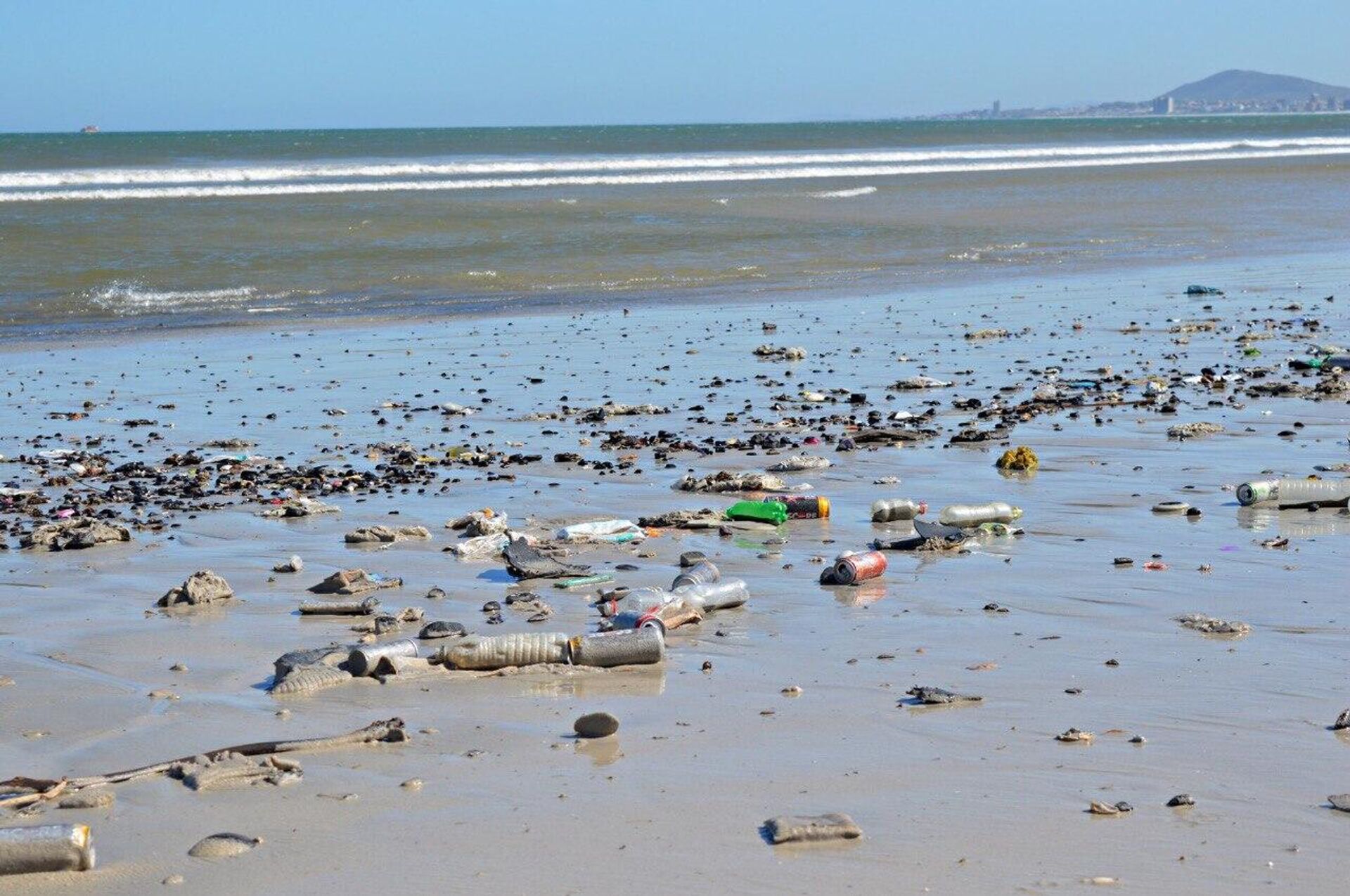An ocean shore in South Africa littered with garbage, including plastic bottles and cans - Sputnik International, 1920, 30.03.2023
