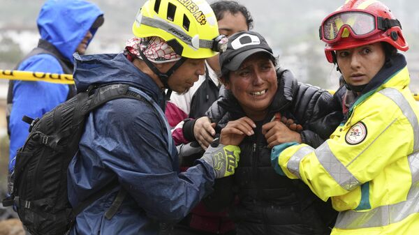 Rescue workers comfort a woman whose daughter is missing in Alausi, Ecuador, Tuesday, March 28, 2023, the day after a landslide swept through the town burying dozens of homes.  - Sputnik International