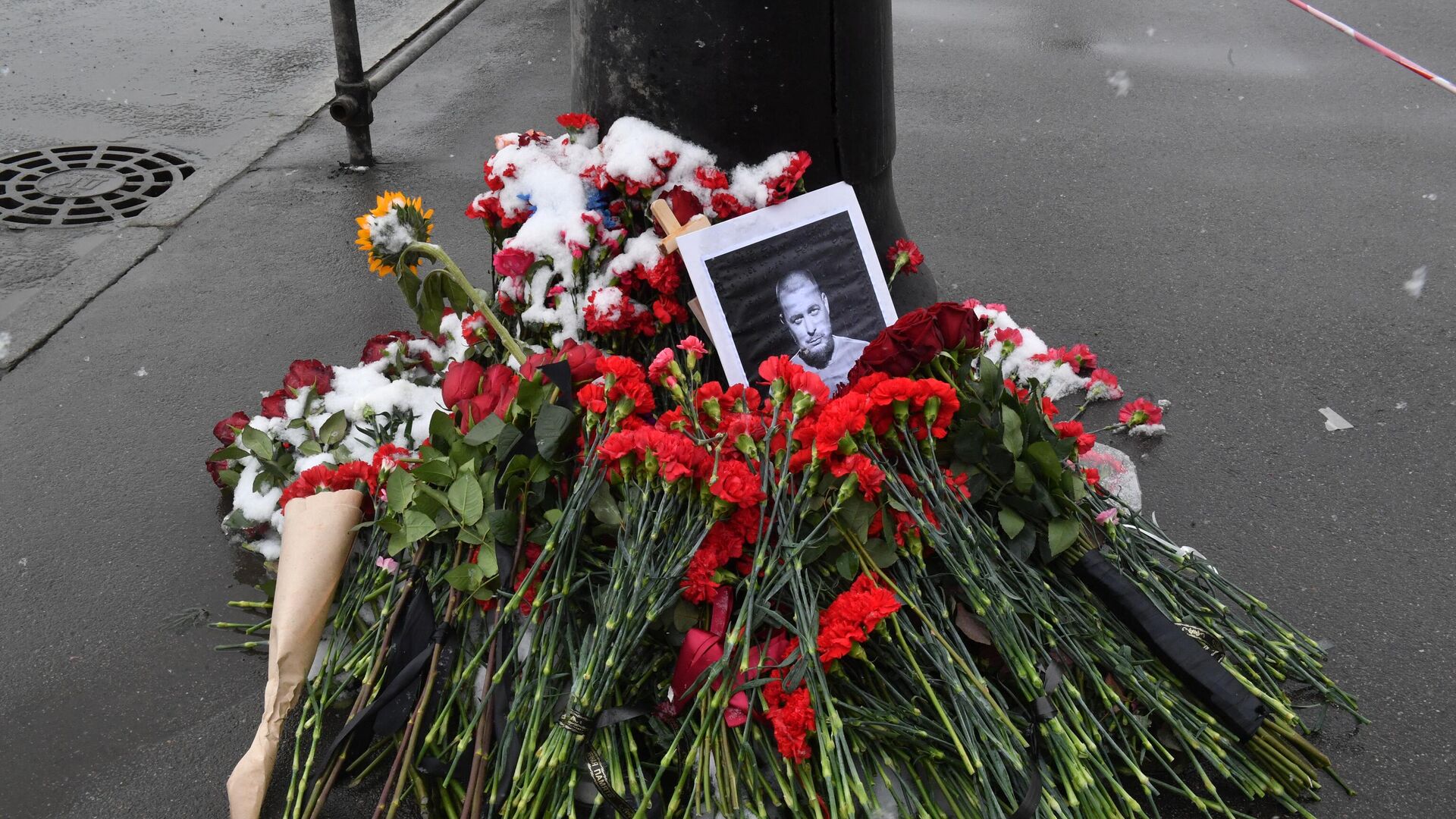 A portrait of Russian military blogger Vladlen Tatarsky, whose real name is Maxim Fomin, who was killed in the April 2 bomb blast in a cafe, is seen among flowers at a makeshift memorial by the explosion site in Saint Petersburg on April 3, 2023.  - Sputnik International, 1920, 03.04.2023