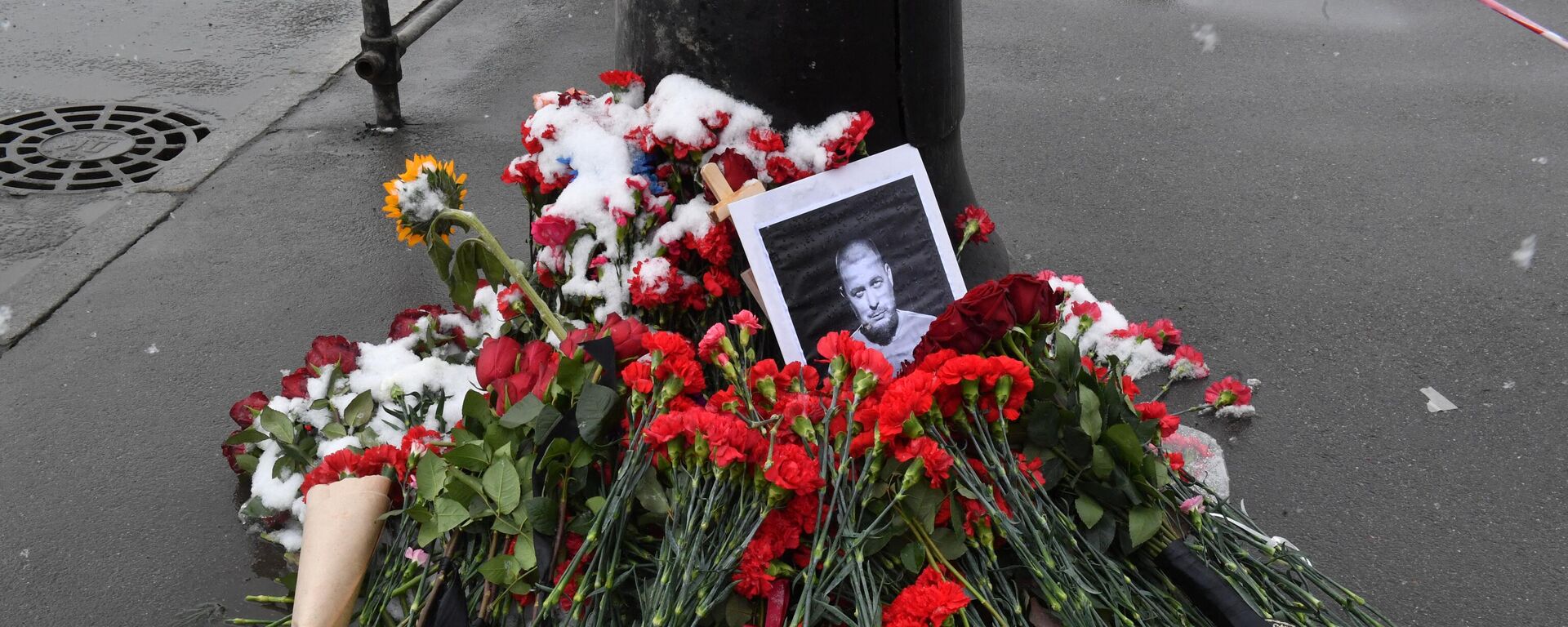 A portrait of Russian military blogger Vladlen Tatarsky, whose real name is Maxim Fomin, who was killed in the April 2 bomb blast in a cafe, is seen among flowers at a makeshift memorial by the explosion site in Saint Petersburg on April 3, 2023.  - Sputnik International, 1920, 03.04.2023