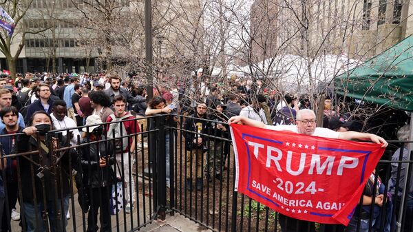 People gather in a park as former US president Donald Trump is arraigned in lower Manhattan on April 4, 2023 in New York.  - Sputnik International