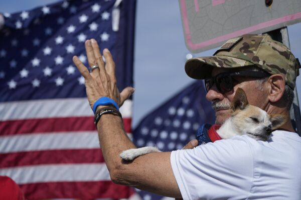 Joe Gonzalez, a supporter of former President Donald Trump, attends a rally with his dog Asti, in West Palm Beach on 4 April 2023. - Sputnik International