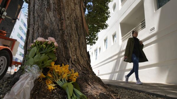 A woman walks past flowers left outside an apartment building where a technology executive Bob Lee was fatally stabbed in San Francisco, Wednesday, April 5, 2023. - Sputnik International