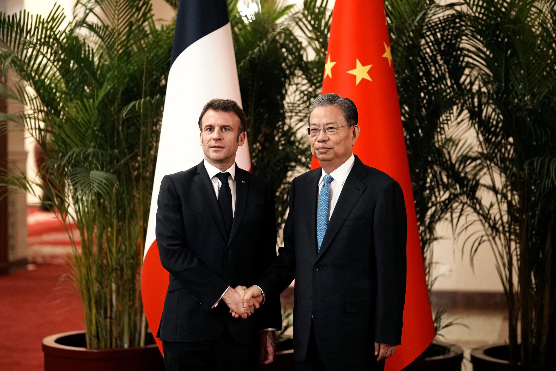 China's National People's Congress Chairman Zhao Leji (R) shakes hands with French President Emmanuel Macron prior to their meeting at the Great Hall of the People in Beijing on April 6, 2023 - Sputnik International, 1920, 06.04.2023