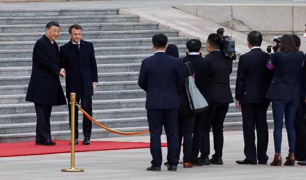 China’s President Xi Jinping (L) shakes hands with his French counterpart Emmanuel Macron as they attend the official welcoming ceremony in Beijing.  - Sputnik International