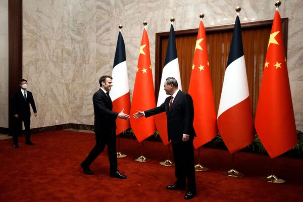 Chinese Premier Li Qiang (R) shakes hands with French President Emmanuel Macron prior to their meeting at the Great Hall of the People in Beijing.  - Sputnik International