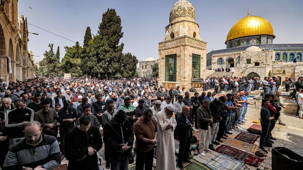 Muslim worshippers pray outside the Dome of the Rock shrine at al-Aqsa mosque compound in the Old City of Jerusalem on April 7, 2023 on the third Friday Noon prayer during the Muslim holy fasting month of Ramada - Sputnik International