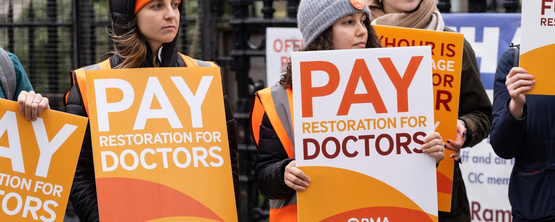 Demonstrators hold placards as they take part in a protest by junior doctors, amid a dispute with the government over pay, outside of Saint Thomas Hospital, in London, on March 13, 2023 - Sputnik International, 1920, 09.04.2023
