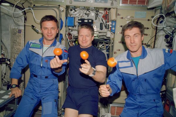 Expedition One crew members about to eat fresh fruit in the form of oranges on board the Zvezda Service Module of the Earth-orbiting International Space Station (ISS) on December 4, 2000. Pictured, from the left, are cosmonaut Yuri P. Gidzenko, Soyuz commander; astronaut William M. Shepherd, mission commander; and cosmonaut Sergey K. Krikalev, flight engineer. - Sputnik International