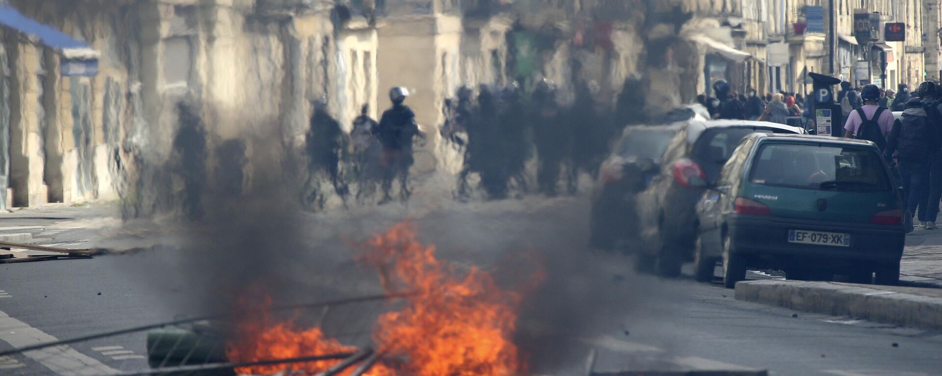 Riot police officers frame demonstrators nest a s street fire during a demonstration against French President Emmanuel Macron's push to move back France's legal retirement age from 62 to 64. - Sputnik International, 1920, 13.04.2023