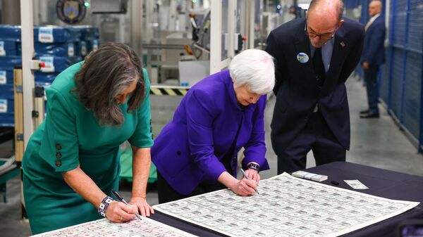 Bureau of Engraving and Printing Director Leonard Olijar (R) watches as US Treasury Secretary Janet Yellen (C) and Treasurer Marilynn Malerba sign one dollar bills at the Bureau of Engraving and Printing Western Currency Facility on December 8, 2022 in Fort Worth, Texas. - The US dollar will bear two women's signatures for the first time, belonging to Treasury Secretary Janet Yellen and Treasurer Lynn Malerba, officials said Thursday as they unveiled the banknotes.  - Sputnik International