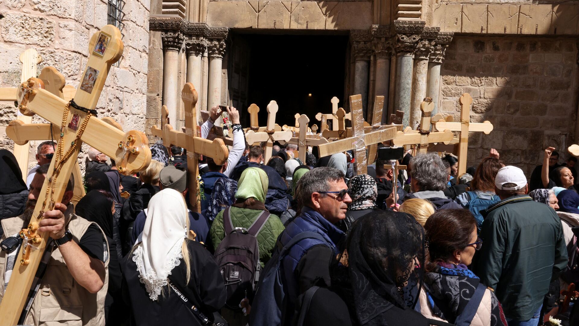 Orthodox Christian pilgrims hold wooden crosses as they gather outside the Holy Sepulchre church during the Holy Friday procession through the Via Dolorosa (Way of Suffering)in Jerusalem's Old City on April 14, 2023.  - Sputnik International, 1920, 15.04.2023