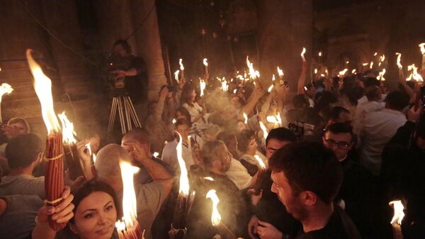 Believers with candles lit from the Holy Fire at the Church of the Holy Sepulchre. - Sputnik International