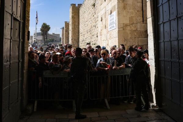 Christian worshippers wait behind a barrier set up by security forces barring the way to the Church of the Holy Sepulcher in Old Jerusalem, during the Orthodox Christian Easter Saturday celebrations. - Sputnik International