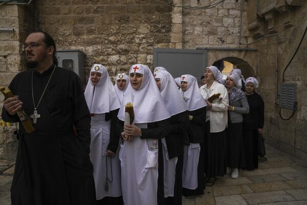 Orthodox Christian clergy and nuns hold candles as they arrive for the Holy Fire ceremony. - Sputnik International