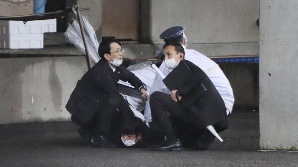 A man (bottom) is arrested after throwing what appeared to be a smoke bomb in Wakayama on April 15, 2023. - Japanese Prime Minister Fumio Kishida was evacuated from a port in Wakayama after a blast was heard, but he was unharmed in the incident, local media reported on April 15.  - Sputnik International