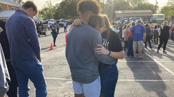 Two teens embrace at a prayer vigil on Sunday, April 16, 2023, outside First Baptist Church in Dadeville, Ala. Several people were killed and over two dozen were injured in a shooting at a teen birthday party in the town on Saturday, April 15. - Sputnik International