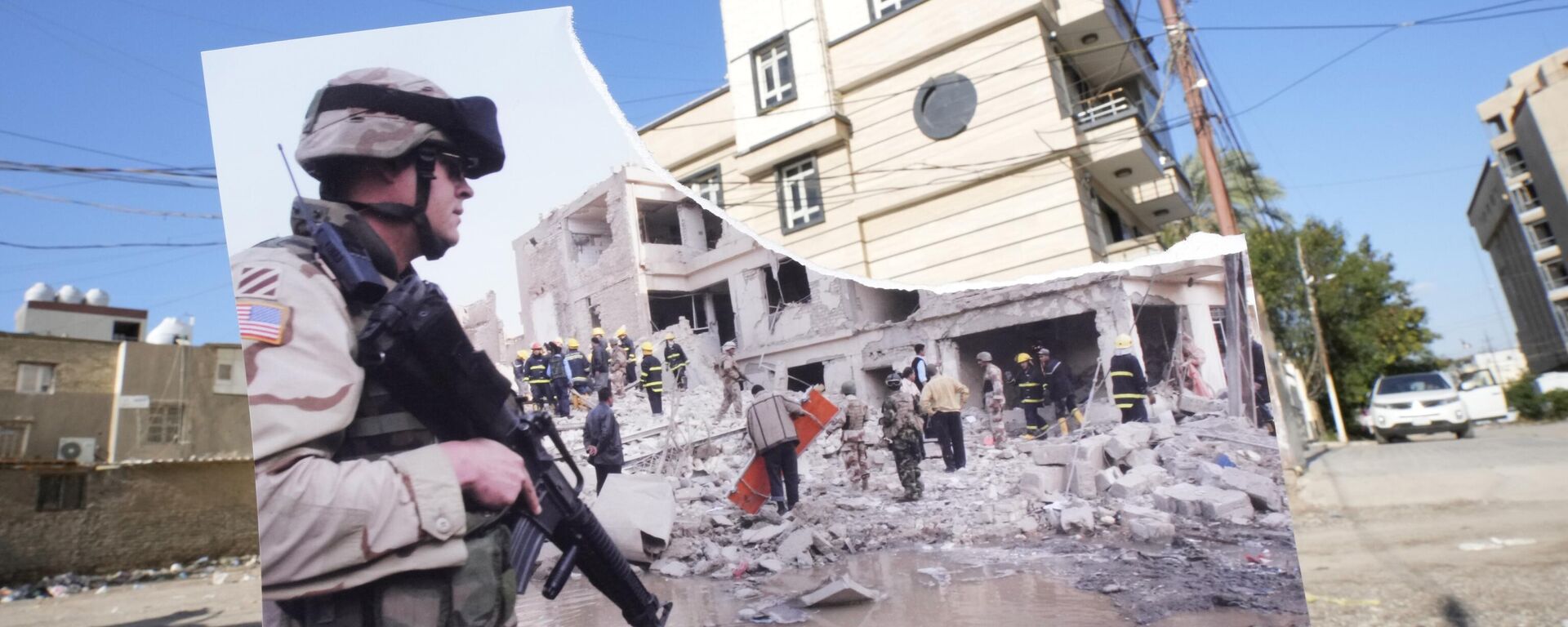 A photograph of a US soldier securing the area near a destroyed building after two car bombs detonated in a central Baghdad residential neighborhood, Friday, Nov. 18, 2005, killing at least six people and wounding dozens, is inserted into the scene at the same location Friday, March 10, 2023, 20 years after the U.S. led invasion on Iraq and subsequent war - Sputnik International, 1920, 27.01.2024