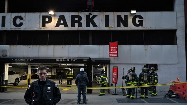 Members of the Fire Department of New York (FDNY) and New York Police Department (NYPD) work at the scene of a parking garage that collapsed in lower Manhattan, New York City, on April 18, 2023. - Sputnik International