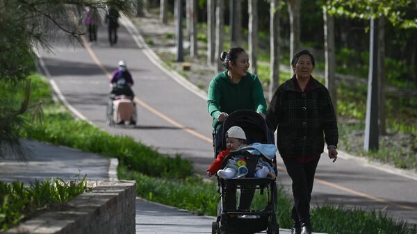 People walk in a public park in Beijing on April 15, 2023.  - Sputnik International