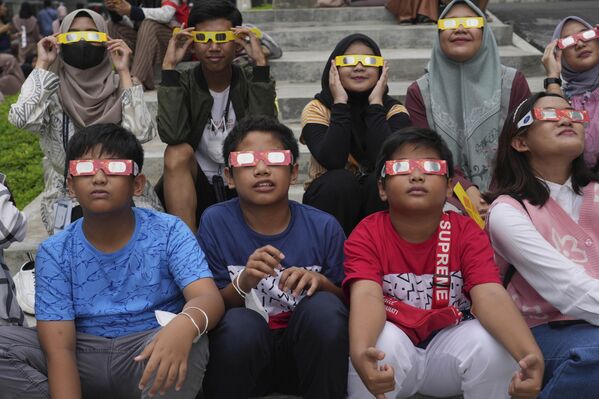 Indonesian youths wear protective glasses to watch the solar eclipse in Jakarta, Indonesia. This rare solar eclipse crossed over remote parts of Australia, Indonesia and East Timor on Thursday. - Sputnik International