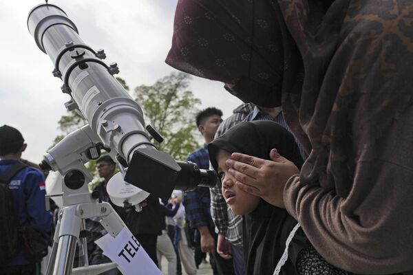 Overall, a hybrid solar eclipse is a rare and stunning event that captivates people from around the world.Above: A woman assists her daughter in looking through a telescope to watch the solar eclipse in Jakarta, Indonesia. - Sputnik International