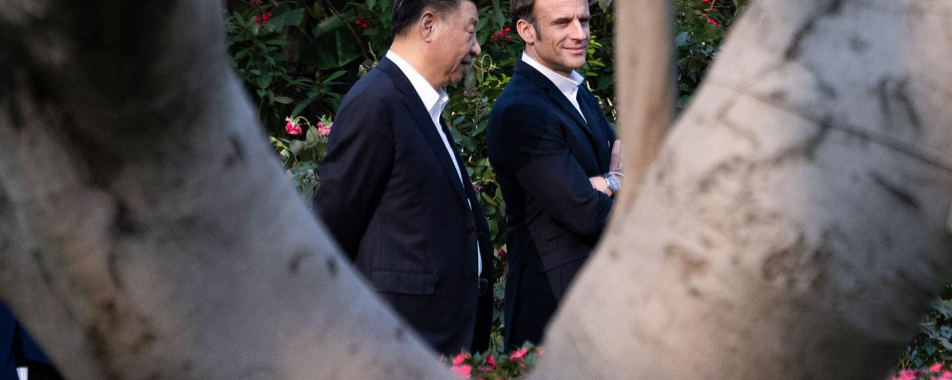 Chinese President Xi Jinping (L) and French President Emmanuel Macron walk in the garden of the residence of the Governor of Guangdong, on April 7, 2023, where Chinese President XI Jinping's father, XI Zhongxun lived. - Sputnik International, 1920, 20.04.2023