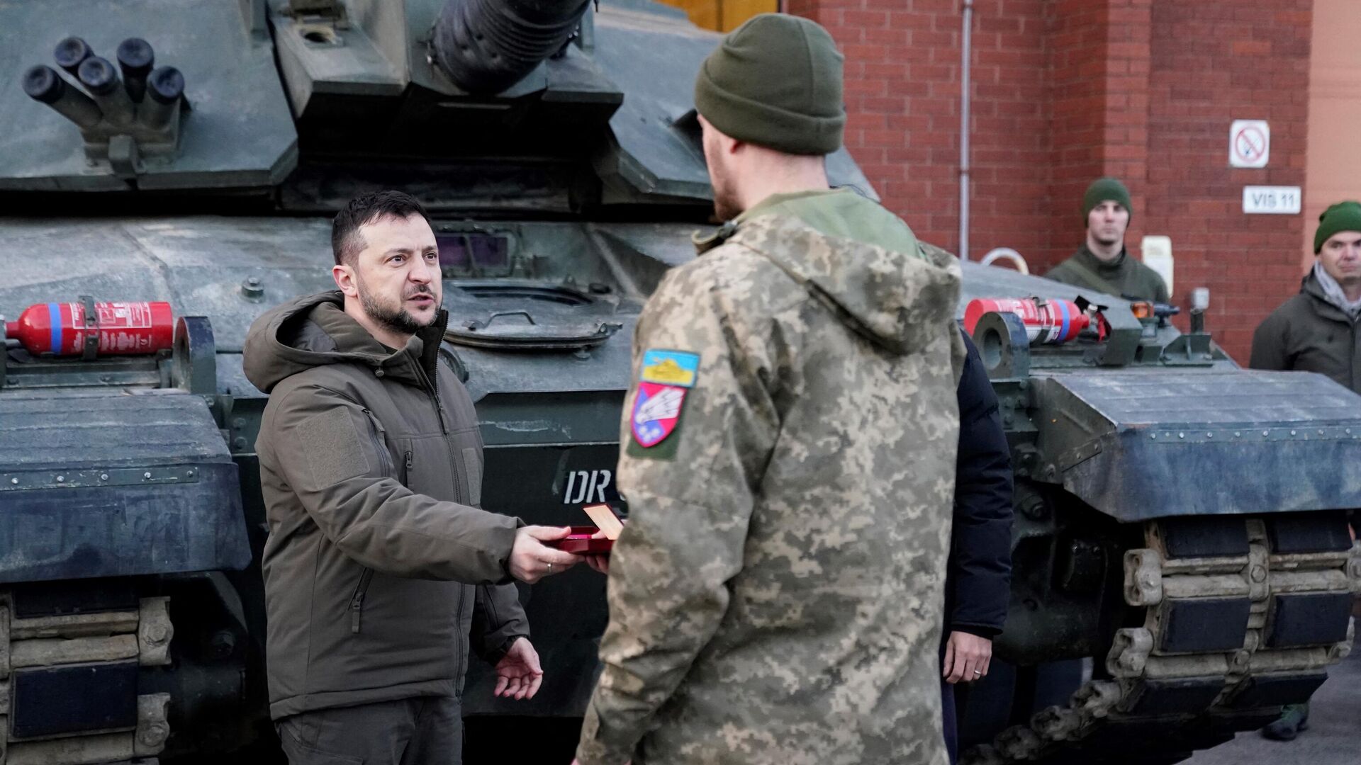 Ukraine's President Volodymyr Zelensky (L) presents a medal as he meets Ukrainian troops being trained to command Challenger 2 tanks at a military facility in Lulworth, Dorset in southern England on February 8, 2023. - Sputnik International, 1920, 21.04.2023
