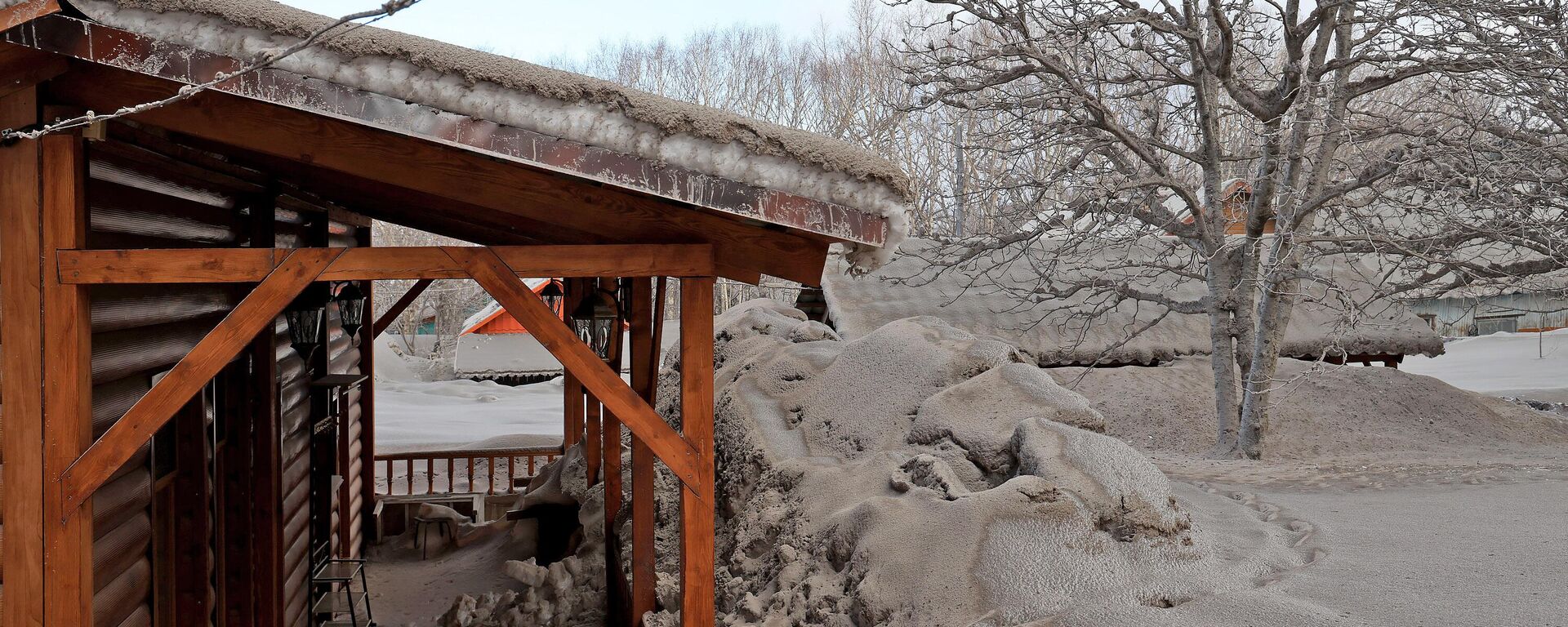 A roof, trees and snowdrifts covered with ashes from the erupting volcano Shiveluch are seen in the Kamchatka Peninsula, Russia.  - Sputnik International, 1920, 22.04.2023