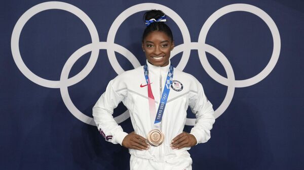 Simone Biles, of the United States, poses wearing her bronze medal from balance beam competition during artistic gymnastics at the 2020 Summer Olympics, Aug. 3, 2021, in Tokyo, Japan.  President Joe Biden will present the nation’s highest civilian honor, the Presidential Medal of Freedom, to 17 people, at the White House next week.  - Sputnik International