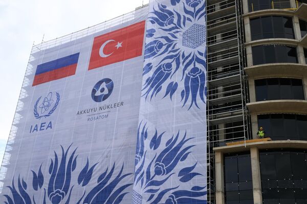 From the moment of fresh nuclear fuel delivery, the Akkuyu station will emerge as a nuclear facility, and Turkiye will become a country with nuclear power industry.Above: Banner covers the Akkuyu nuclear power plant under construction in Gulnar, Turkiye - Sputnik International
