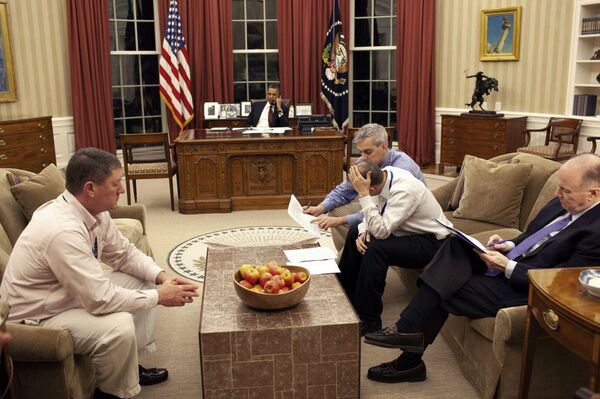 Obama on the phone while, deputy national security advisor Denis McDonough, speech writer Ben Rhodes, and national security advisor Tom Donilon sit on the right couch. The man on the left couch is unidentified. - Sputnik International