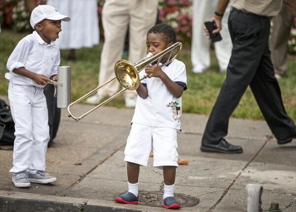 Youngsters raised in the traditional music of the Southern &quot;shout bands&quot; mirror the music of their elders as believers gather on Memorial Day weekend. Inspired by jazz, gospel, and Dixieland, the pulsing trombones gradually intensify their call, bringing hundreds of worshipers to their feet while firehoses provide a spiritual soaking outside the church.  - Sputnik International