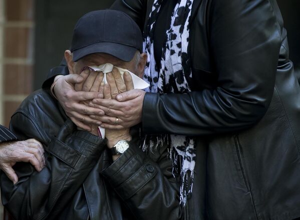An elderly relative breaks down into tears at the coffin of 17-year-old Vadim Papura, who died jumping out of the Trade Unions House.   - Sputnik International