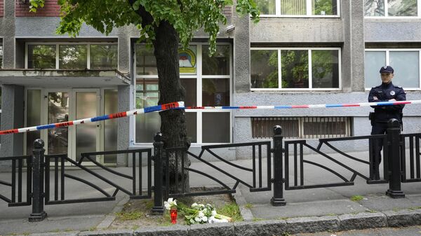 Policeman stands in front of the Ribnikar school in Belgrade, Serbia, Wednesday, May 3, 2023. Police say a 13-year-old who opened fire at his school drew sketches of classrooms and made a list of people he intended to target. He killed eight fellow students and a school guard before being arrested Wednesday. - Sputnik International