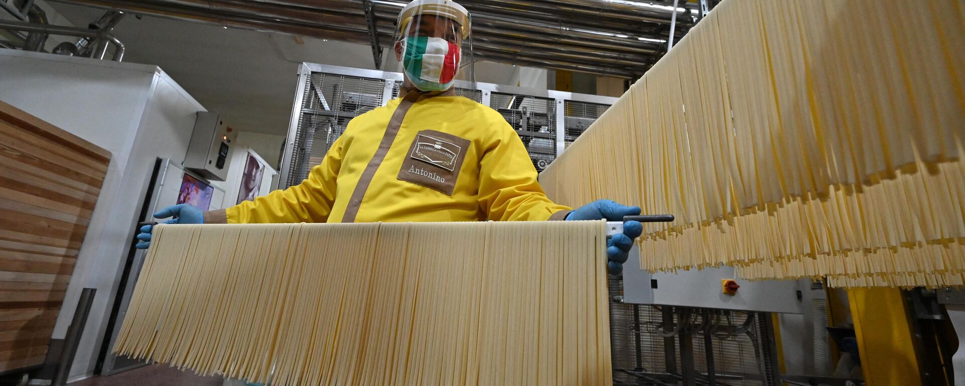 Co-owner with his three brothers and production manager of the Pasta di Gragnano factory near Naples, Antonino Moccia, wearing a face mask in the colors of the Italian flag, processes tagliatelle pasta at the production line on April 24, 2020. - Sputnik International, 1920, 05.05.2023