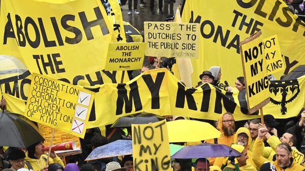 Protesters hold signs along the route of the procession ahead of the coronation of King Charles III and Camilla, the Queen Consort, in London, Saturday, May 6, 2023. - Sputnik International